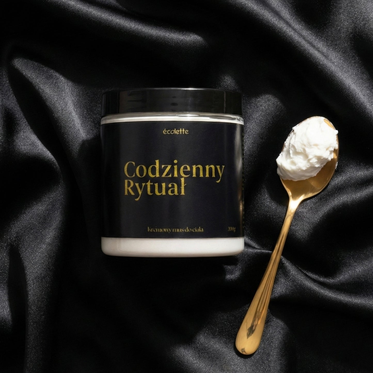 Mus Codzienny Rytuał Écolette w aranżacji na czarnej satynie ze złotą łyżeczką do nabierania musu.