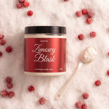 Mus do ciała Zimowy Blask Écolette w aranżacji na śniegu z żurawiną, podkreślającej zimowy klimat produktu.