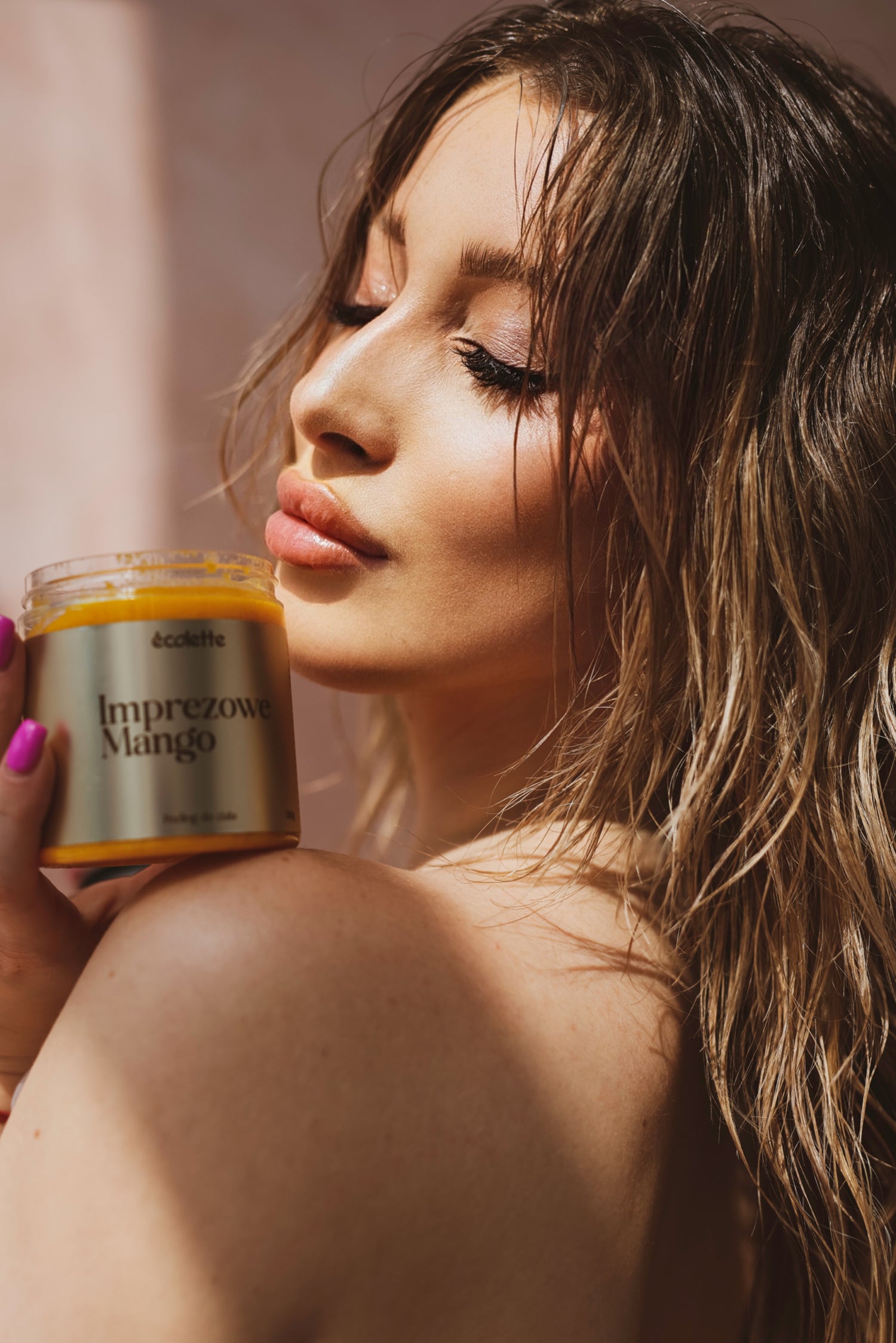 Osoba prezentuje naturalny peeling do ciała Imprezowe Mango Écolette o świeżym, owocowym zapachu i odżywiającej formule.