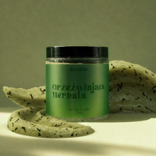 Peeling Orzeźwiająca Herbata Écolette w aranżacji z zieloną herbatą i plasterkami cytryny podkreślającymi świeży aromat.